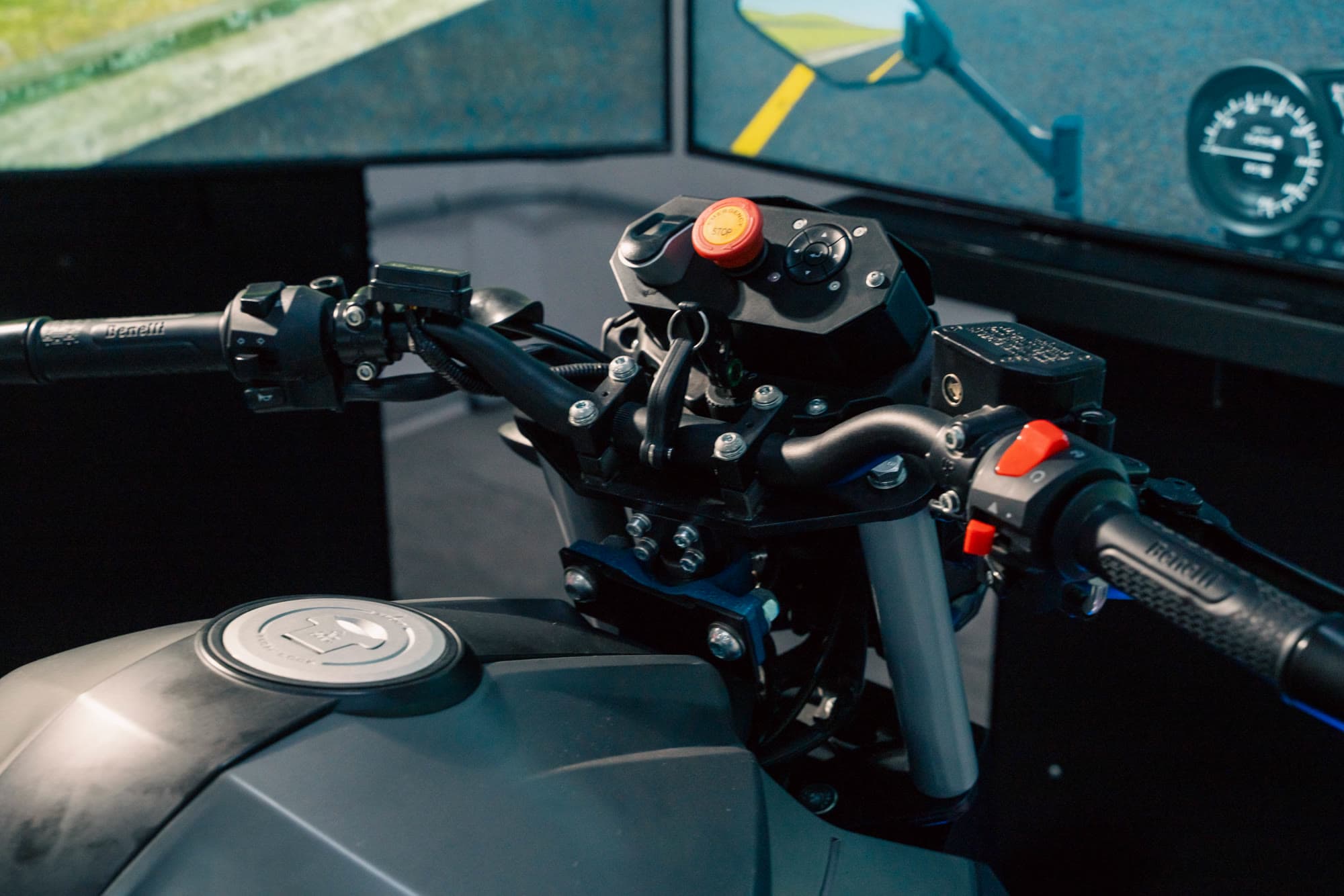 Detalle del manubrio con mandos reales del simulador de motocicleta APEX